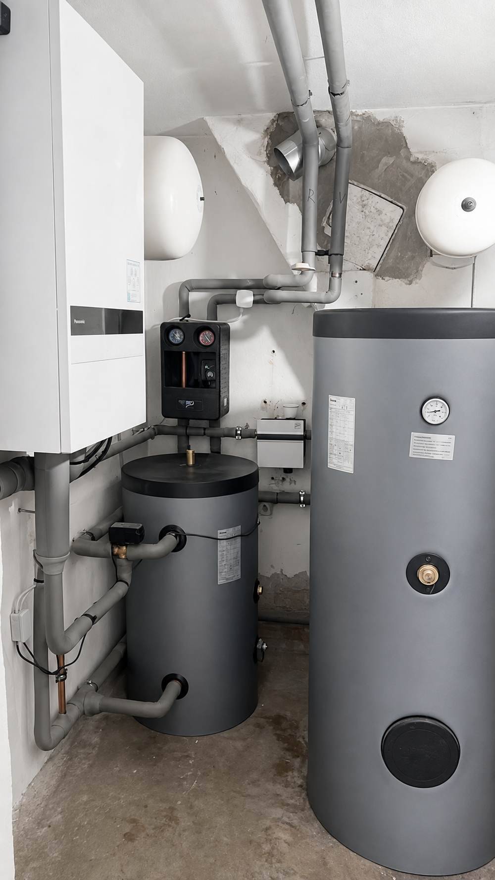 Technikraum mit wandhängender Hydraulikeinheit, Pufferspeicher und Warmwasserspeicher