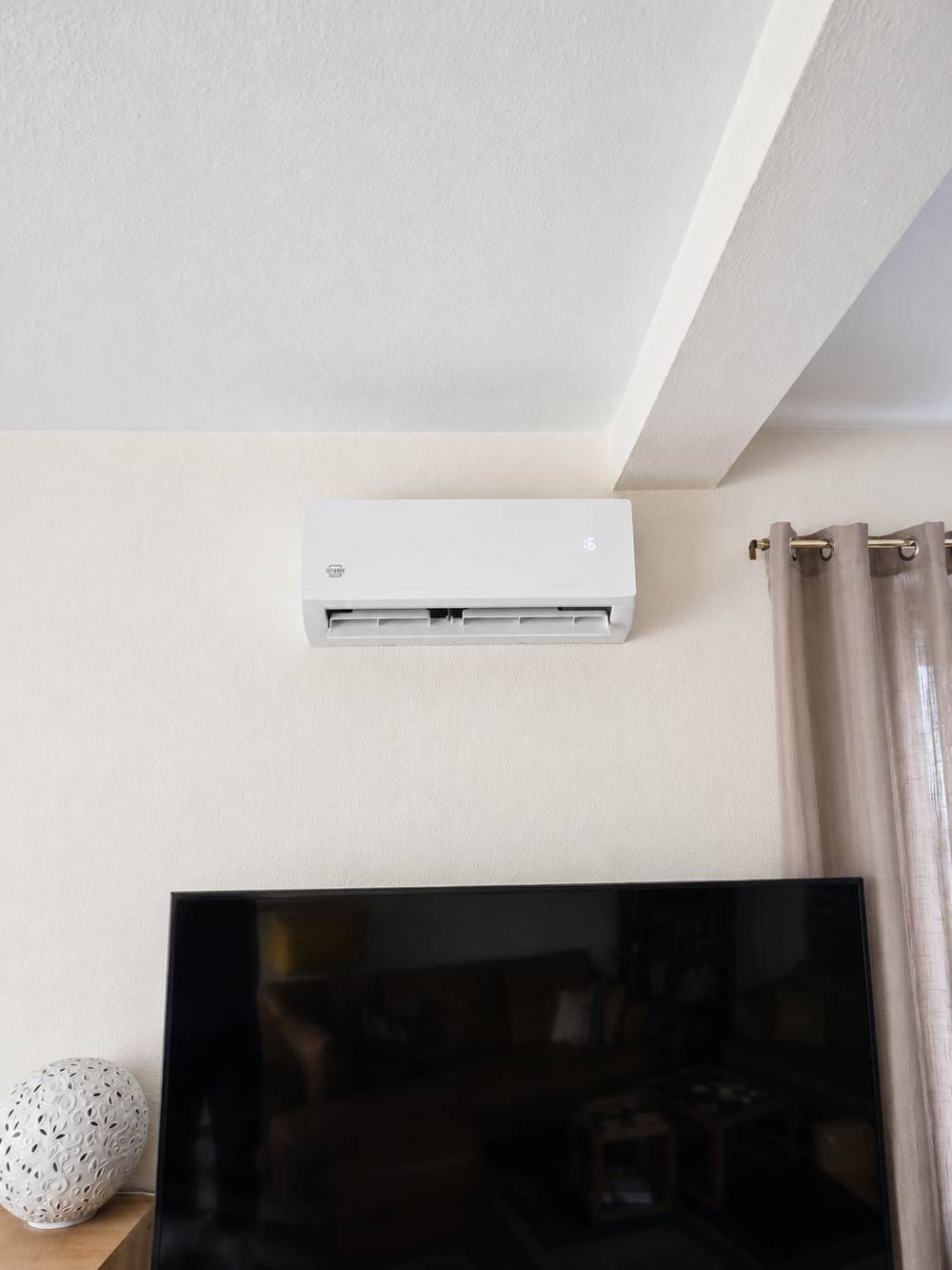 Wandgerät der Klimaanlage im Wohnzimmer über dem Fernseher montiert